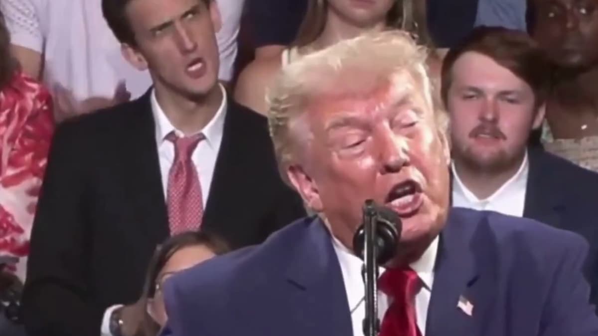 An American behind US President Trump at his Georgia rally imitated him